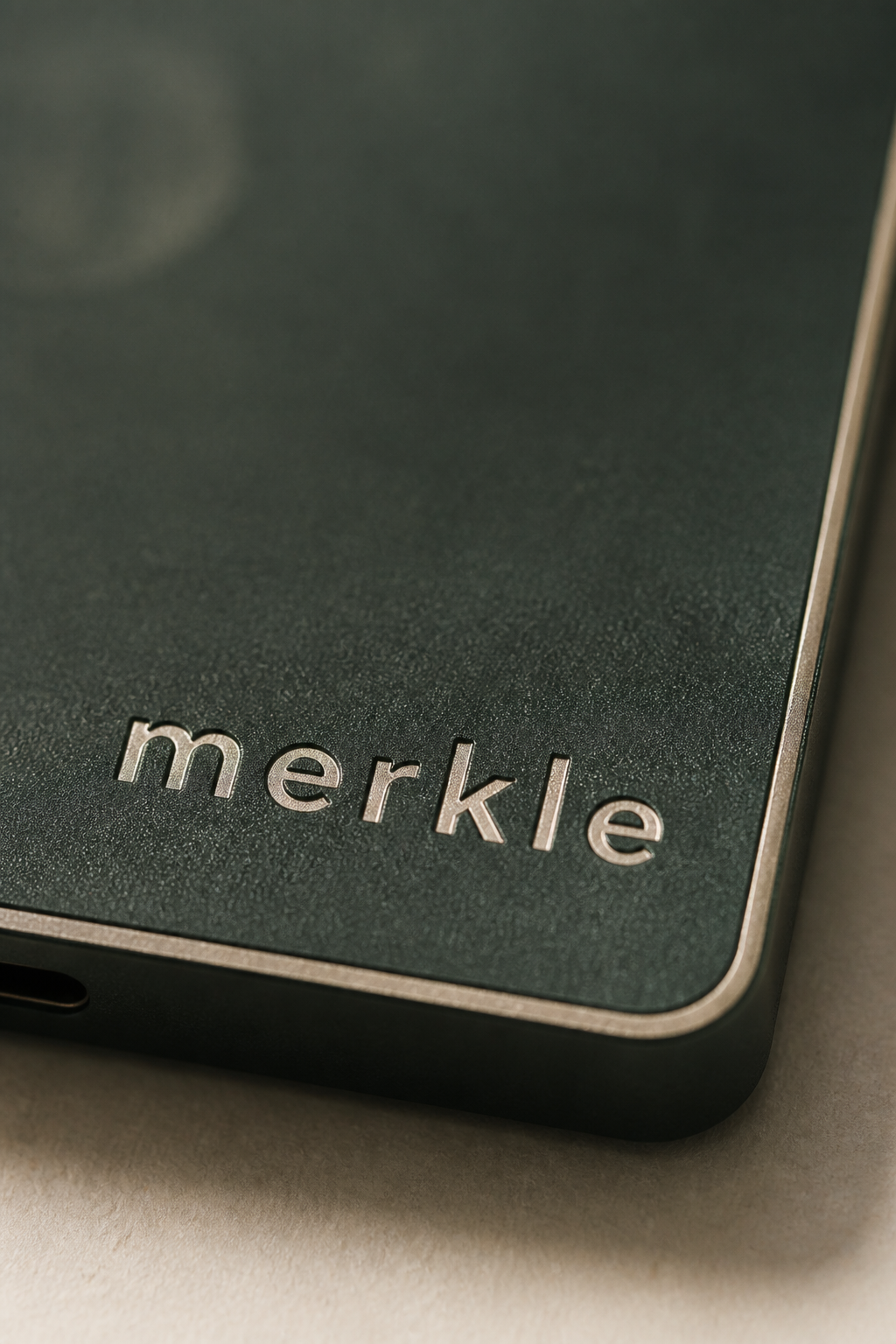 Macro of the cream merkle lettering embossed in forest-green aluminium